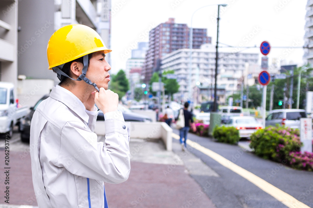 街を見回る作業着の男性 街を見回る作業着の男性