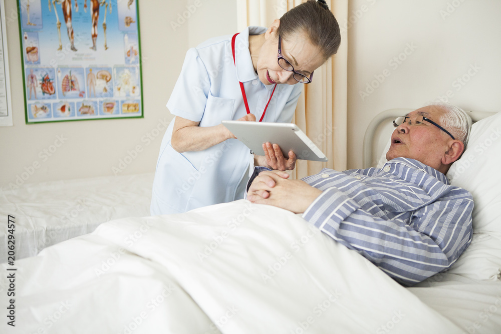 看護師がタブレットを患者に見せて、説明をしている。