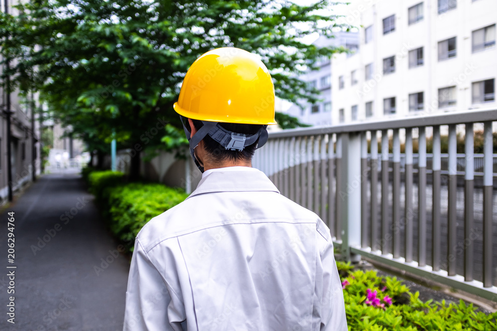 街を眺める作業着の男性