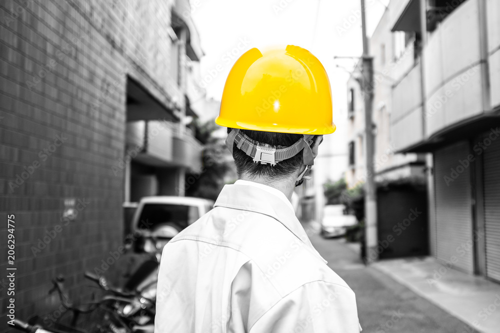 街を眺める作業着の男性