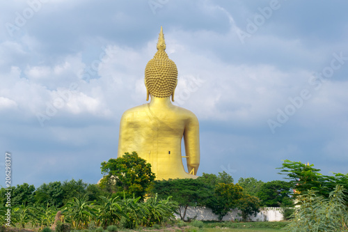 Backside of biggest golden Buddha statue on the green field in Thailand at Wat Muang, Ang Thong Province, Thailand.