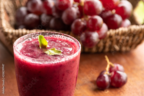 Foto Glass of Grape juice smoothie on wooden table