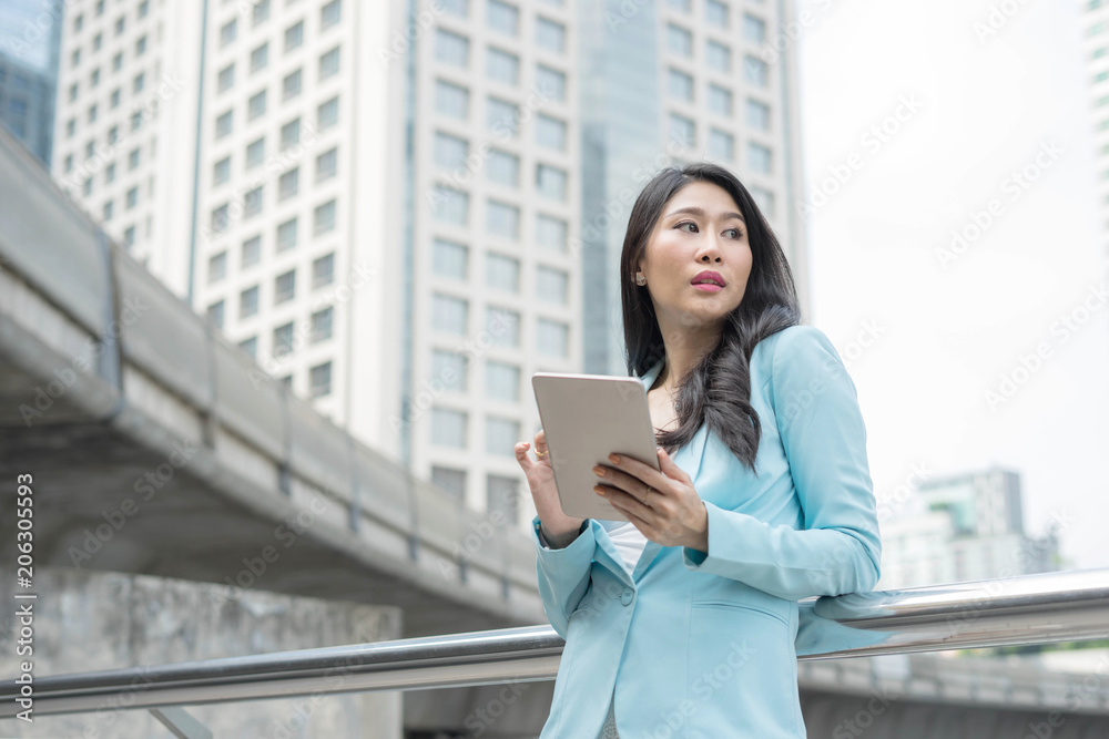 Beautiful cute girl business woman clothes holding a smart phone, urban city background Beautiful cute girl business woman clothes holding a smart phone, urban city background