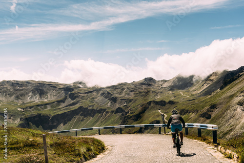 Rear view of woman riding bicycle on mountain road