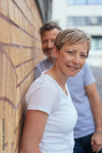 Smiling mature woman leaning against wall