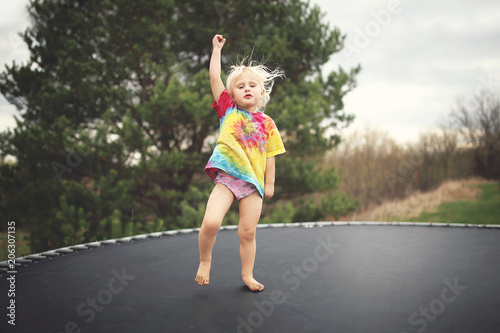 Vintage Style Photo of Country Kid Jumping on Trampoline Outside