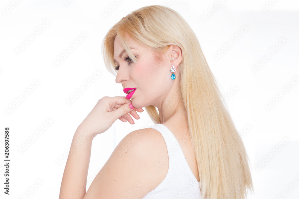 Close Up beauty portrait blonde with long hair, she with bright makeup, pink lips. Green eyes. Blue earrings. White background Close Up beauty portrait blonde with long hair, she with bright makeup, pink lips. Green eyes. Blue earrings. White background