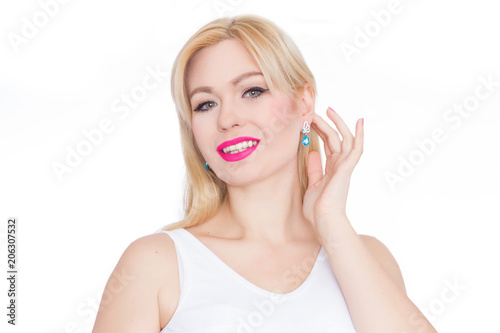 Close Up beauty portrait blonde with long hair, she with bright makeup, pink lips. Green eyes. Blue earrings. White background