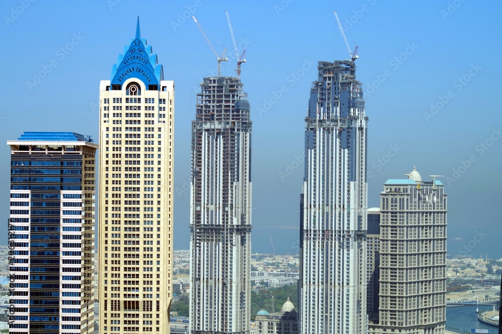 Tall skyscrapers in Dubai Business Bay with beautiful blue sky in background. Tall skyscrapers in Dubai Business Bay with beautiful blue sky in background.