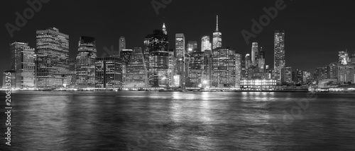 New York City skyline reflected in the East River at night, USA.