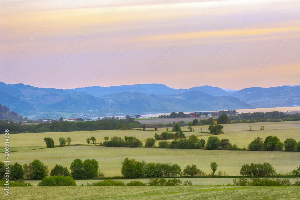 Obraz premium Agricultural area Oesand, Norway, at warm spring sunset 