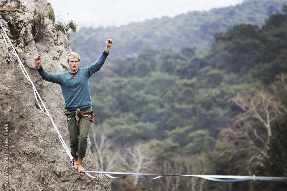 Highliner on a rope. Highline on a background of mountains. Extreme