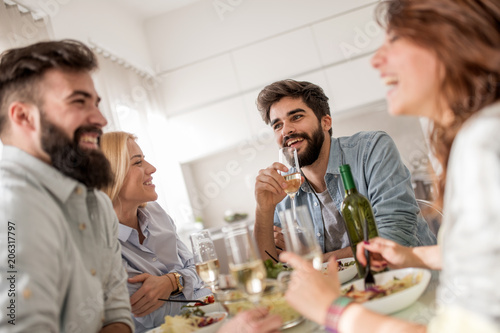 Positive happy young people enjoying food at home