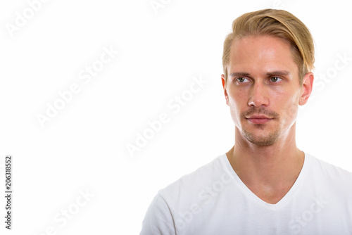 Studio shot of young handsome man thinking while looking at dist