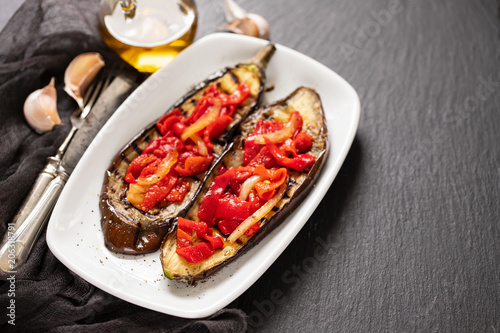 grilled eggplant with red pepper on white dish