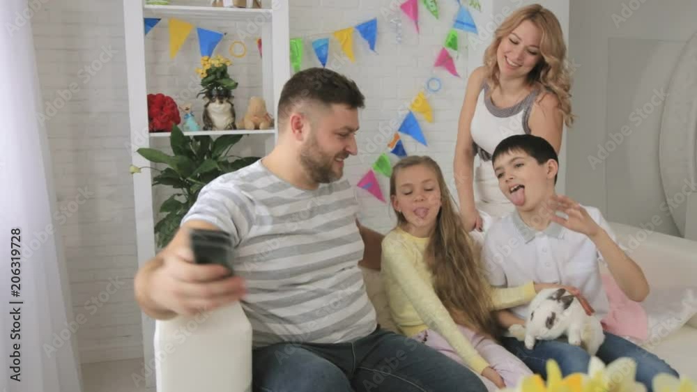 Happy cheerful family with a rabbit on their hands making selfie Happy cheerful family with a rabbit on their hands making selfie