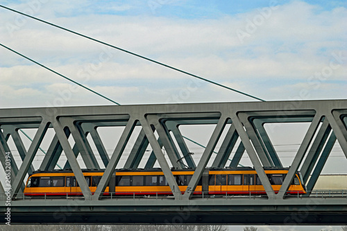 Straßenbahn fährt über Eisenbahnbrücke