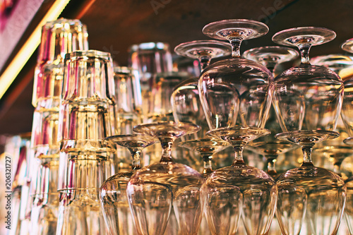 Different glassware and drinkware such as glasses and cognac snifters at a bar or restaurant with beautiful bokeh