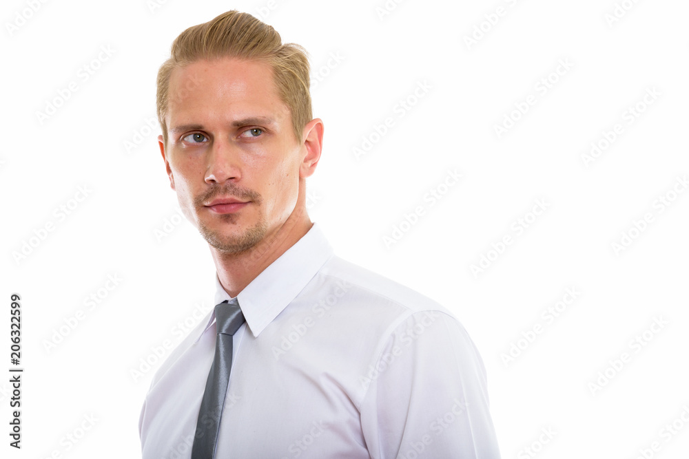 Studio shot of young handsome businessman thinking while looking Studio shot of young handsome businessman thinking while looking