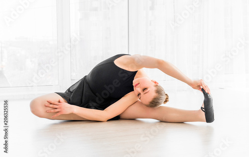 Ballerina sitting on tiptoe on the floor