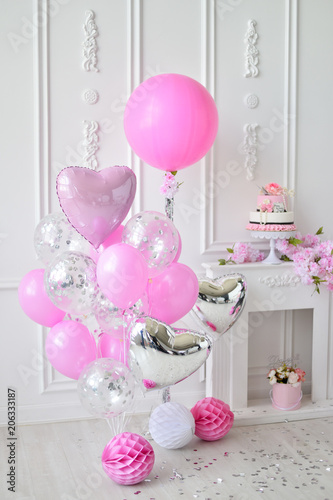 A lot of balloons pink and white colors. Decorations for birthday party. Cake for holiday party. 