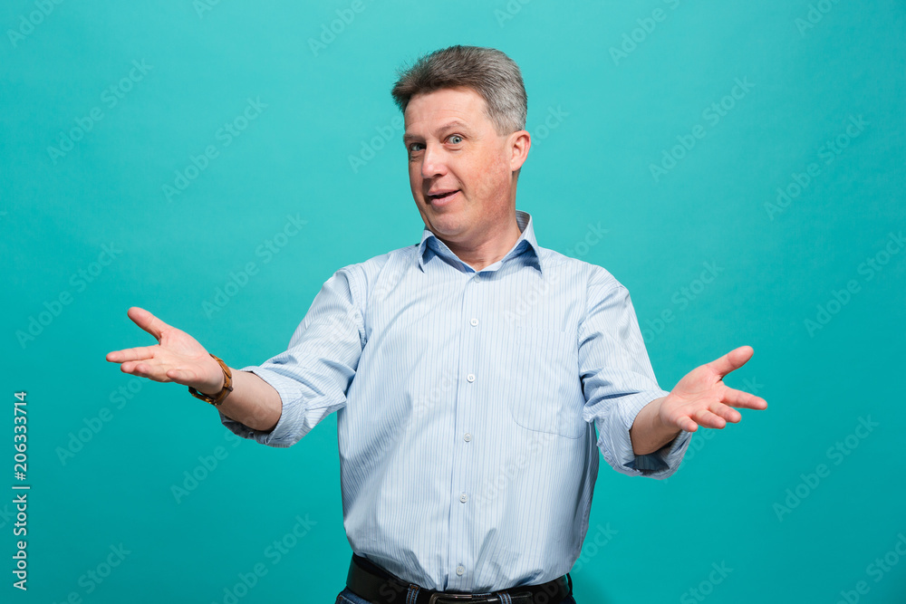 Beautiful male half-length portrait isolated on blue studio backgroud. The senior emotional surprised man Beautiful male half-length portrait isolated on blue studio backgroud. The senior emotional surprised man
