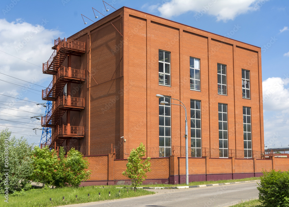 The building of a small factory of red brick. Production building with balconies. The building of a small factory of red brick. Production building with balconies.