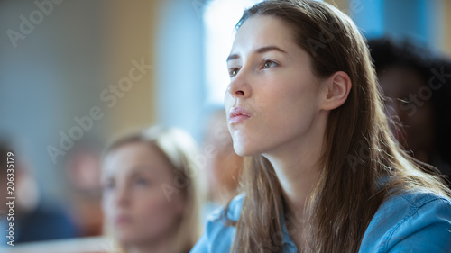 Beautiful Young Girl Listening to a Lecture in a Classroom. Diverse Group of Multi Ethnic Students Study at the University.