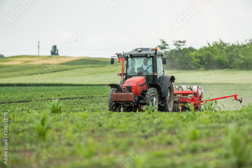 Farmer seeding  sowing crops at field. Sowing is the process of planting seeds in the ground as part of the early spring time agricultural activities.