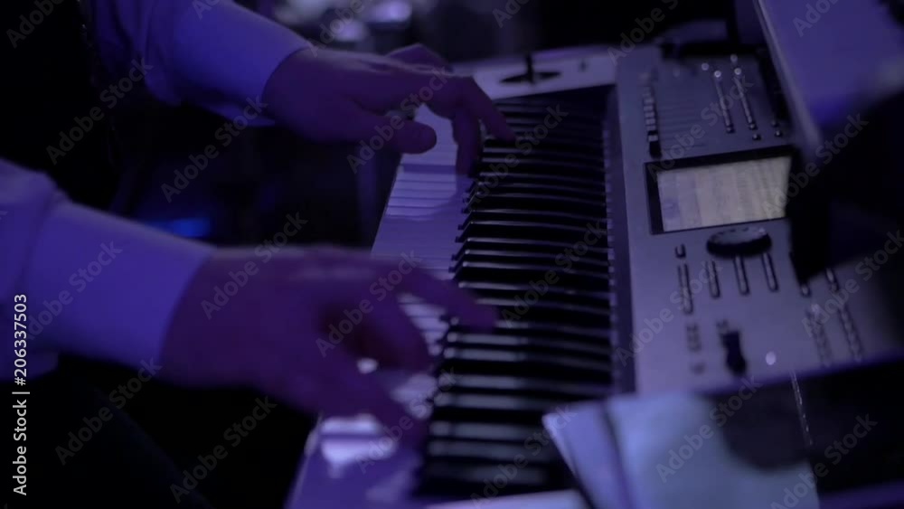 White hands playing synth keyboards indoor