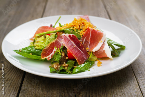 Delicious salad of prosciutto and vegetables restaurant serving. Mediterranean food, appetizer, banquet, restaurant menu, dining concept