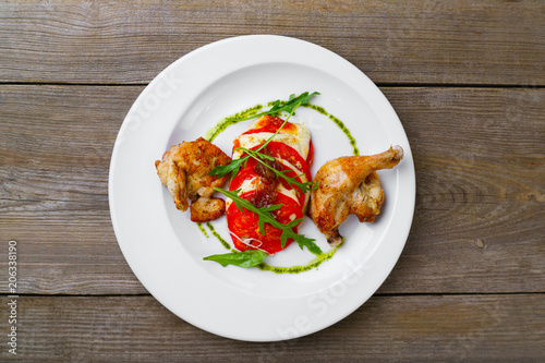 Baked quail legs garnished with caprese, delicious Italian food, banquet, restaurant menu, dining concept