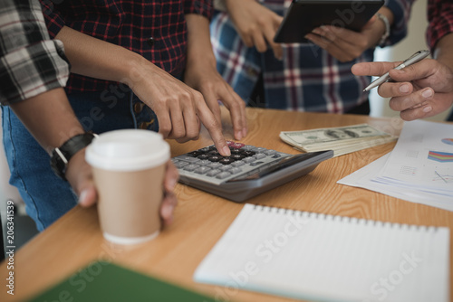 Group business man and woman use calculator. She is calculated the share of business