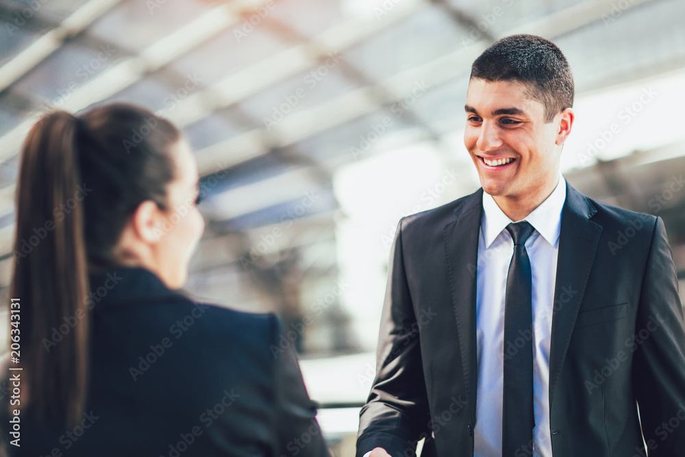 Businessman And Businesswomen Shaking Hands Outside Office