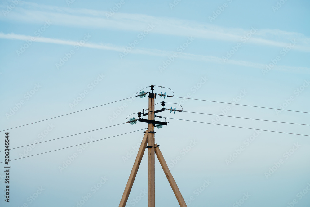 Power lines on background of blue sky close-up. Electric hub on pole. Electricity equipment with copy space. Wires of high voltage in sky. Electricity industry. Power lines on background of blue sky close-up. Electric hub on pole. Electricity equipment with copy space. Wires of high voltage in sky. Electricity industry.