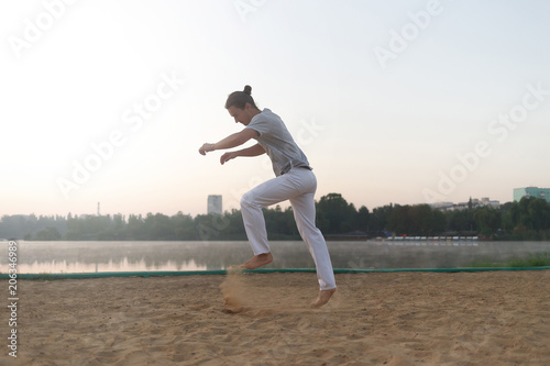 Casual athletic man get ready to jump on the beach while workout
