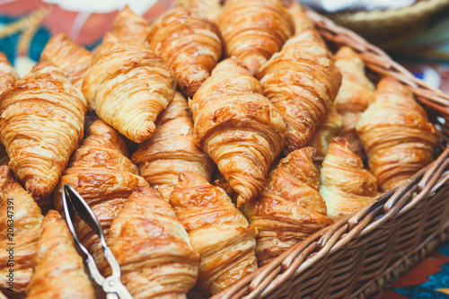 Beautifully decorated catering banquet table with variety of different pastry and bakery, with croissants and cookies on corporate christmas birthday party event or wedding celebration