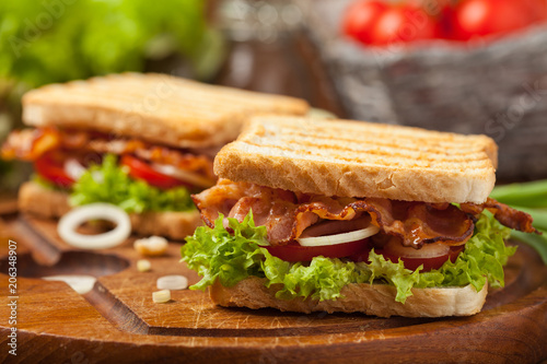 Toasted sandwich with bacon, tomato, cucumber and lettuce.