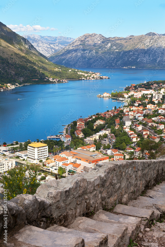 Montenegro. A beautiful view of the blue waters of Kotor Bay, the coastal city of Kotor and the Old Town road with a medieval stone stairs to the Fort of St. Ivan