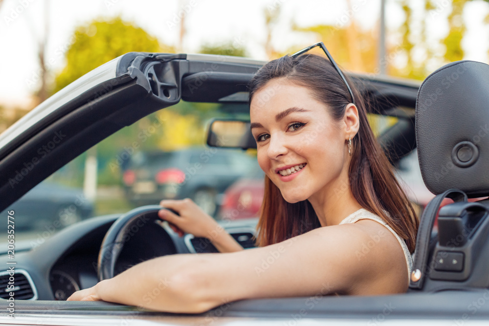 Beautiful girl in the convertible cabrio car on a sunny day in a city Beautiful girl in the convertible cabrio car on a sunny day in a city
