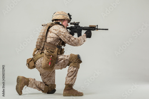 Soldier in camouflage holding rifle