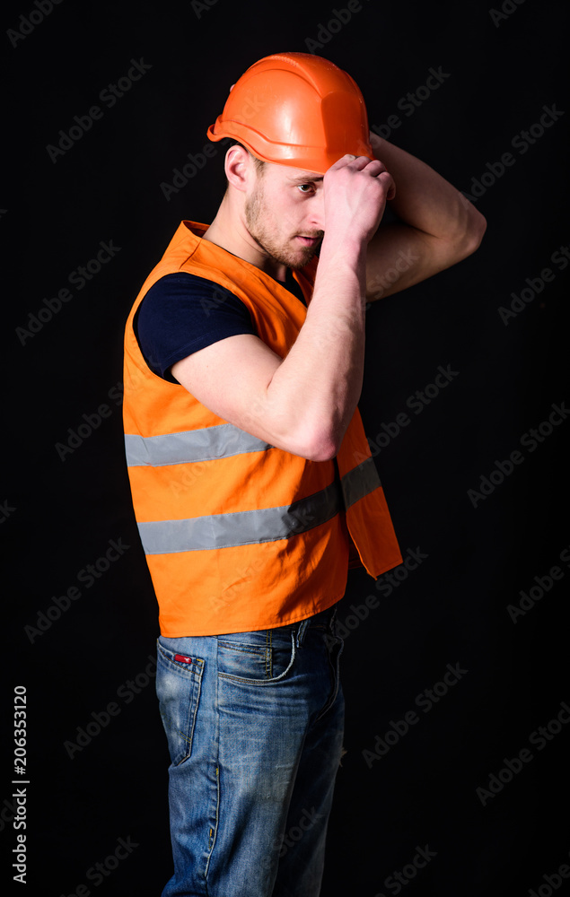 Attractive builder concept. Builder in helmet posing confidently ...