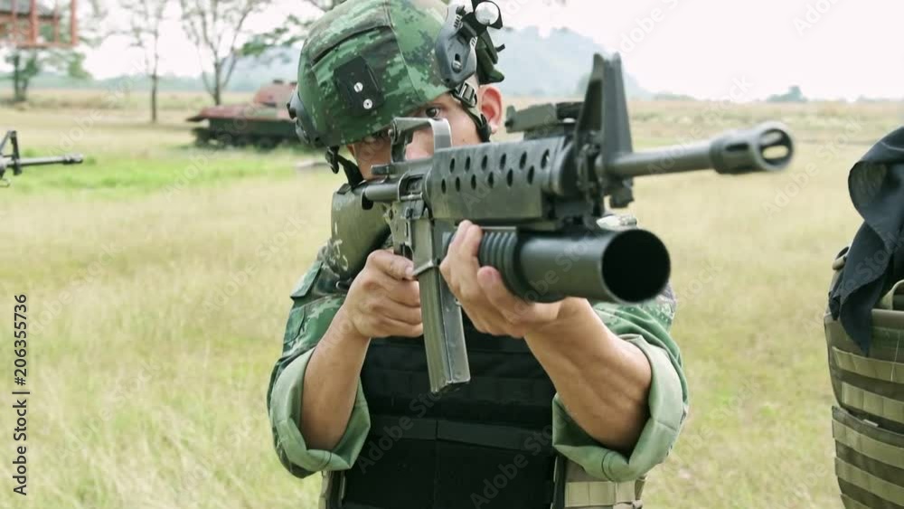 Slow motion of soldier aiming his assault rifle on grass. Chinese soldier on grass land standing and aiming his assault rifle, special forces training. Ready to assault terrorist. Slow motion of soldier aiming his assault rifle on grass. Chinese soldier on grass land standing and aiming his assault rifle, special forces training. Ready to assault terrorist.