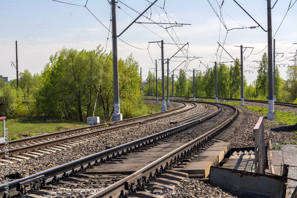 A sharp turn of the Railway. Three ways. Poles with electrical wire. Summer