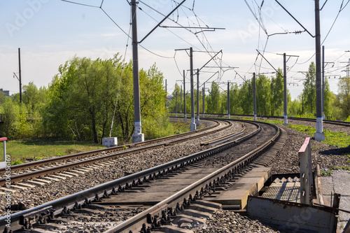 A sharp turn of the Railway. Three ways. Poles with electrical wire. Summer