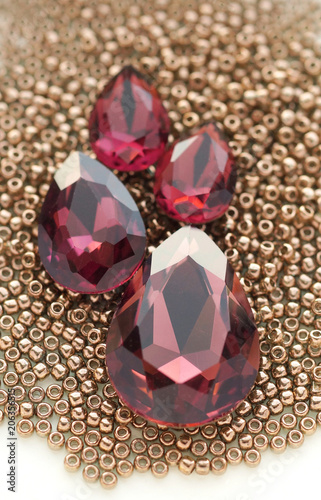 Shiny burgundy crystal rhinestones and metallic seed beads closeup background
