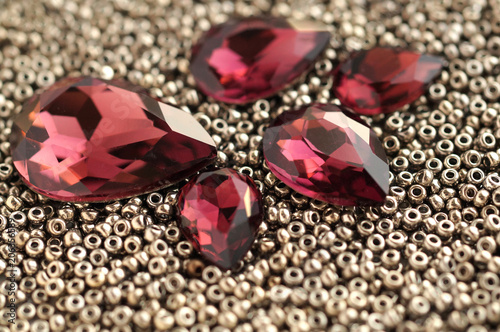 Shiny burgundy crystal rhinestones and metallic seed beads closeup background