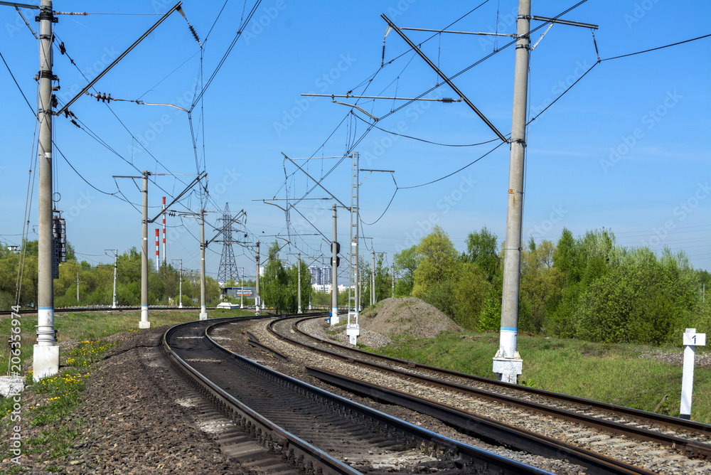 A sharp turn of the Railway. Three ways. Poles with electrical wire. Summer