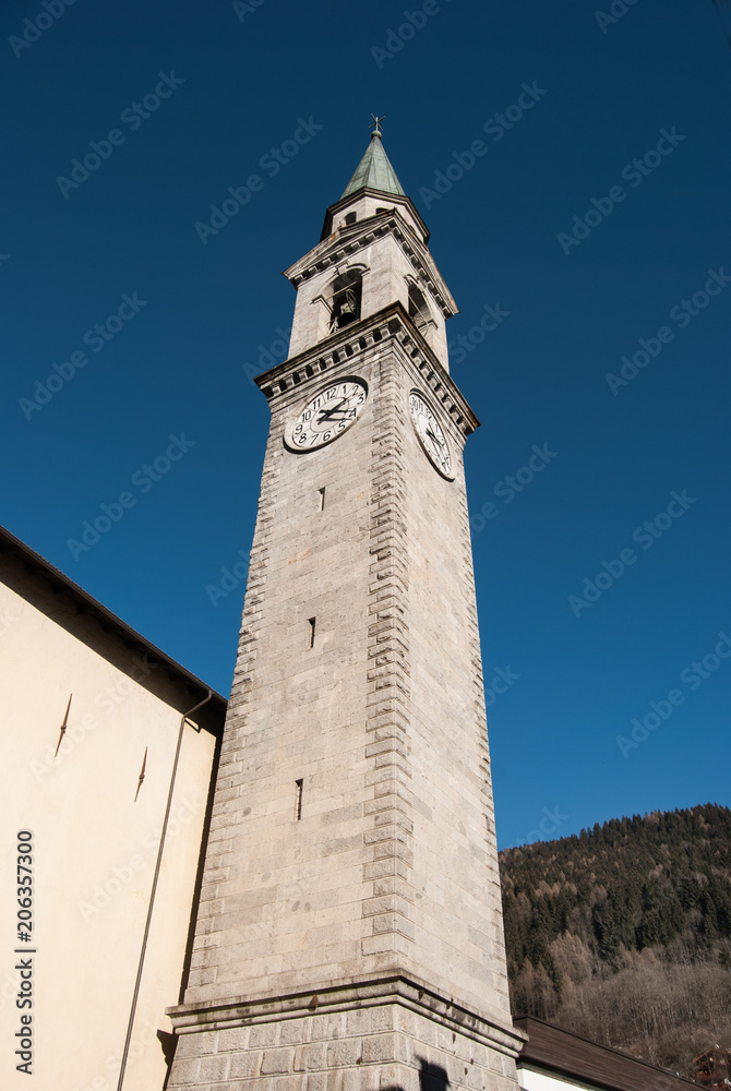 Tower bell of the main church with blue sky in Pinzolo
