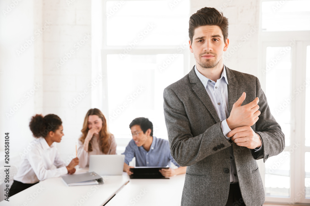 Confident young man standing at the table